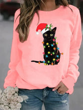 Load image into Gallery viewer, A person wearing a pink sweatshirt with a graphic of a black cat wearing a Santa hat and adorned with Christmas lights.  Twinkle Paws Christmas Cat Sweatshirt - Christmas - JBCoolCats