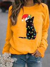 Load image into Gallery viewer, A person wearing a yellow sweatshirt with a graphic of a black cat wearing a Santa hat and adorned with Christmas lights.  Twinkle Paws Christmas Cat Sweatshirt - Christmas - JBCoolCats