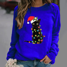 Load image into Gallery viewer, A person wearing a Blue sweatshirt with a graphic of a black cat wearing a Santa hat and adorned with Christmas lights. Twinkle Paws Christmas Cat Sweatshirt - Christmas - JBCoolCats