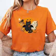 Load image into Gallery viewer, Person wearing an orange t-shirt with Halloween-themed cat graphics.Witchy Moonlight Meowgic Halloween Tee - Orange - Orange - JBCoolCats