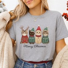 Load image into Gallery viewer, Person wearing a gray t-shirt with Christmas-themed cat illustrations and 'Meowy Christmas' text. Festive Feline Friends Tee - Light Gray - JBCoolCats