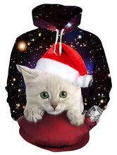 Load image into Gallery viewer, Christmas hoodie featuring a light gray kitten in a red Santa hat resting on a red surface, set against a starry outer space background with bright galaxies. Kitty Cuteness Christmas Hoodie - Christmas Clothing - JBCoolCats