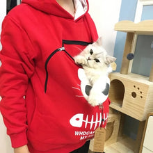 Load image into Gallery viewer, Person wearing a red hoodie with a cat carrier, holding a white cat. Snuggle‑Me Pet Pouch Hoodie - Cozy Coral Red - JBCoolCats 