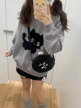 Load image into Gallery viewer, Person wearing a gray sweater with a black cat design, holding a matching black bag. Mischief Meow Cozy Cat Sweater - Alt View- JBCoolCats