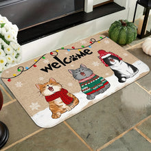 Load image into Gallery viewer, Decorative doormat with cartoon cats wearing Christmas sweaters and lights, on a stone floor. Welcome Cat Holiday Doormat - Christmas - JBCoolCats