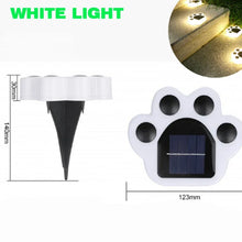 Load image into Gallery viewer, Solar lawn lights in the shape of cat paws, glowing in the dark, indicating they are illuminated. Cat Paw Solar Lawn Lights - White Light - JBCoolCats