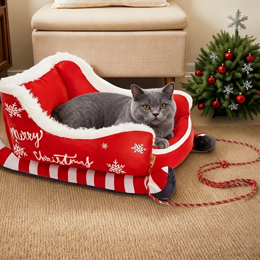 Gray cat in a red 'Merry Christmas' pet bed with a decorated tree in the background - Feline Express Sleigh Bed - Small - JBCoolCats