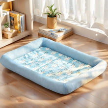 Load image into Gallery viewer, Blue pet bed with cartoon design on a wooden floor, surrounded by books and a plant. Cool Cat Summer Silk Retreat Bed - Chillwave Blue - JBCoolCats