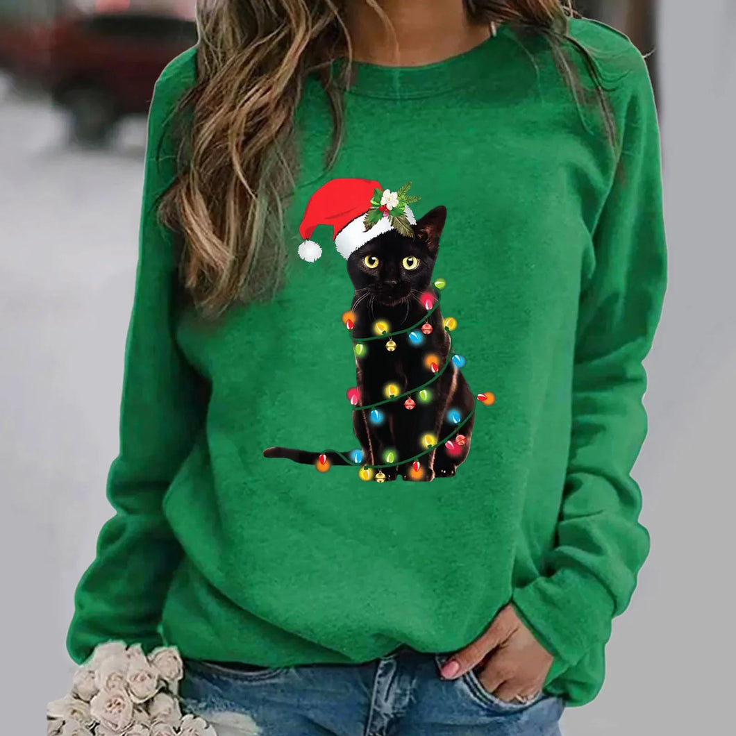 A person wearing a green sweatshirt with a graphic of a black cat wearing a Santa hat and adorned with Christmas lights.  Twinkle Paws Christmas Cat Sweatshirt - Christmas - JBCoolCats
