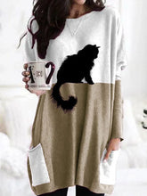 Load image into Gallery viewer, Woman wearing a long-sleeve white &amp; khaki dress with a black cat design, holding a mug.   - JBCoolCats